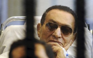 Former Egyptian President Mubarak sits inside a cage in a courtroom at the police academy in Cairo